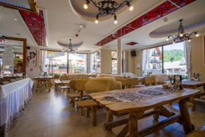 a restaurant with wooden tables and chairs and windows at Residence Spa Harenda in Zakopane