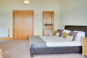 a bedroom with a large bed in a room at Squirrels Leap Lake Views with Spa Access, Lower Mill Estate in Somerford Keynes +61 photos