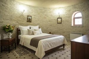 a bedroom with a large bed and a stone wall at Castel Unghern in Ivancea