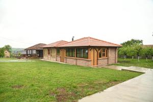 a house with a grassy yard in front of it at Kutak u Vranicu in Vranic