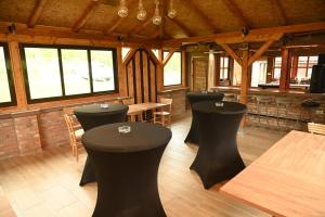 a restaurant with black stools in the middle of a room at Kutak u Vranicu in Vranic