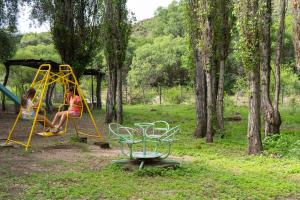 two children playing on a playground in a park at Finca La Media Luna in San Agustín de Valle Fértil