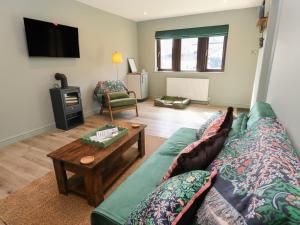 a living room with a green couch and a coffee table at Underview in Holmfirth