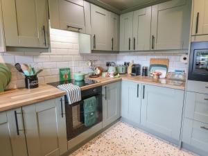 a kitchen with white cabinets and a stove top oven at Underview in Holmfirth