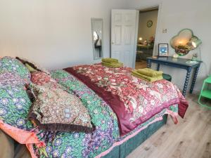 a bed with colorful blankets and pillows in a room at Underview in Holmfirth