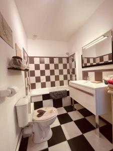 a bathroom with a black and white checkered floor at Villa des Sarcelles in Le Crotoy +61 photos