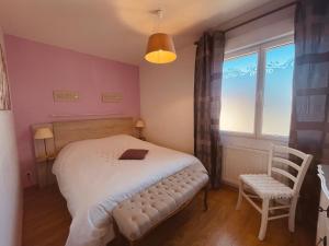 a bedroom with a bed and a chair and a window at Villa des Sarcelles in Le Crotoy