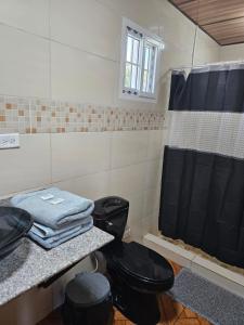 a bathroom with two black toilets and a shower at Tocumen Comfort Stay in Aserrío