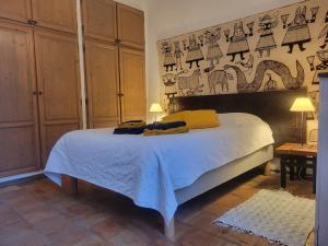 a bedroom with a bed and a wall with pictures at le rocher de Sampzon in Sampzon