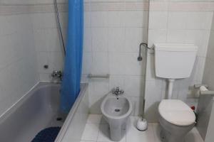 a bathroom with a toilet and a bath tub with a sink at Sweet West in Lourinhã