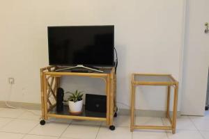 a television on a tv stand with a table at Sweet West in Lourinhã
