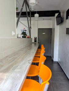 a row of orange chairs sitting at a long counter at Hôtel de Clèves in Nevers