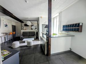 a kitchen and living room with a couch and a table at Hôtel de Clèves in Nevers