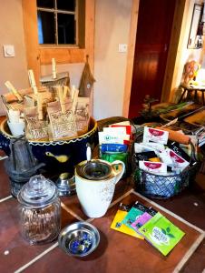 a table with bowls and cups and other items on it at Maison d'hôtes complète La Paulusmühle in Soucht