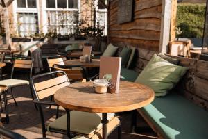 a wooden table and chairs on a patio at Koffie&kussens in Middelburg