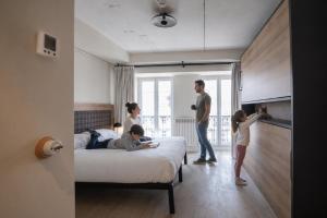 a family standing in a bedroom with a bed at LATROUPE Grand Place in Brussels