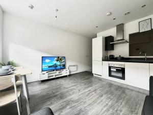 a living room with a television and a kitchen at Digbeth Luxury 1 Bed Studio Apartment in Birmingham +31 photos