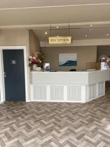a reception area with a white counter in a room at The Windsor House Hotel in Worthing