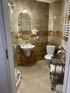 a bathroom with a sink and a toilet and a mirror at Kamienica przy Bramie in Opatów +53 photos