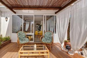 a porch with two chairs and a coffee table at Casa Do Canto in Cascais