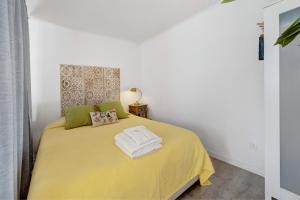 a bedroom with a yellow bed with a yellow blanket at Casa Do Canto in Cascais