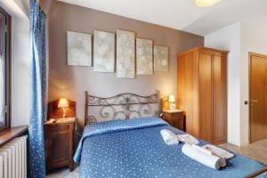 a bedroom with a blue bed with two towels on it at Terraluna in Monforte dʼAlba