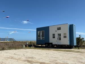 a tiny house sitting on the side of a beach at Oceanfront Tiny Retreat in Holden Beach