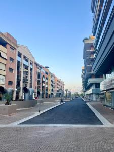 an empty street in a city with tall buildings at Domus Leonardo Apartment in Fiumicino Airport