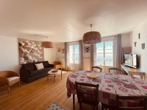 a living room with a table and a couch at Villa des Sarcelles in Le Crotoy