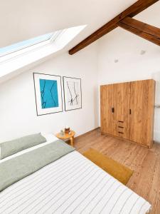 a bedroom with two beds and a wooden cabinet at Ferienwohnung Nikolaiblick in Stralsund