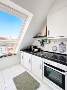 a kitchen with white appliances and a large window at Ferienwohnung Nikolaiblick in Stralsund +15 photos