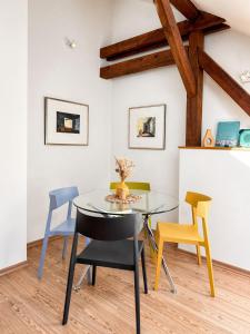 a dining room with a glass table and chairs at Ferienwohnung Nikolaiblick in Stralsund