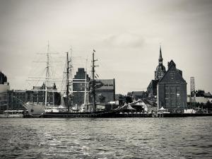 a large ship docked in a harbor next to a city at Ferienwohnung Nikolaiblick in Stralsund