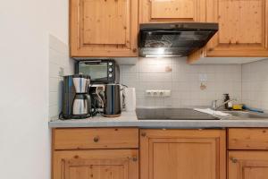 a kitchen with wooden cabinets and a counter top at Apartment mit Gartenblick K1 206 in Spalt