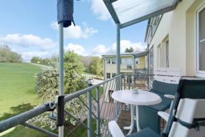 a patio with a table and chairs on a balcony at Apartment mit Gartenblick K1 206 in Spalt