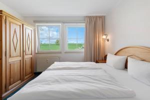 a bedroom with a large white bed and a window at Apartment mit Gartenblick K1 206 in Spalt