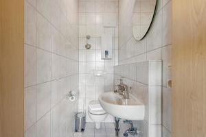 a white bathroom with a sink and a toilet at Apartment mit Gartenblick K1 206 in Spalt +16 photos