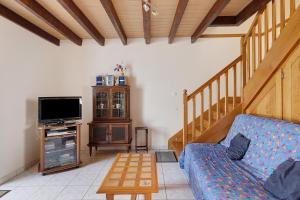a living room with a couch and a flat screen tv at Gîte La Chapelière in Assay