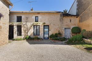 an old brick house with a driveway in front of it at Gite À La Tite Boulite in Vouneuil-sous-Biard