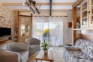 a living room with a couch and chairs and a tv at Gite À La Tite Boulite in Vouneuil-sous-Biard