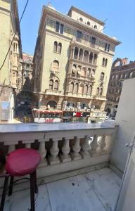 a red stool sitting on a balcony with a building at Dawn tawn velavet in Cairo +22 photos