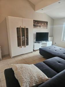 a living room with two beds and a flat screen tv at Appartement T2 in Vaugneray