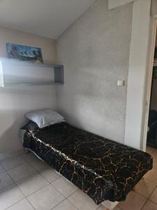 a small bedroom with a bed in a room at Appartement T2 in Vaugneray