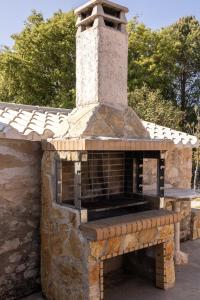 an outdoor brick oven with a stone wall at Green Oak Villa in Orthoniaí