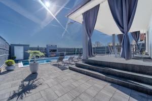 a rooftop patio with chairs and a pool on a building at Holiday Villa Pervan in Sesvete