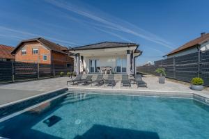 a swimming pool in front of a house at Holiday Villa Pervan in Sesvete