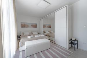 a white bedroom with a bed and a mirror at Holiday Villa Pervan in Sesvete +57 photos
