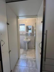 a bathroom with a shower and a sink and a toilet at Yolonwabo Bed & Beakfast in East London +29 photos