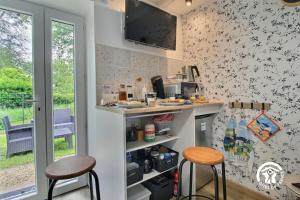 a kitchen with two stools and a counter and a tv at Le tigîte b&b in Allaire +17 photos