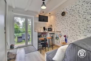a living room with a couch and a table with chairs at Le tigîte b&b in Allaire